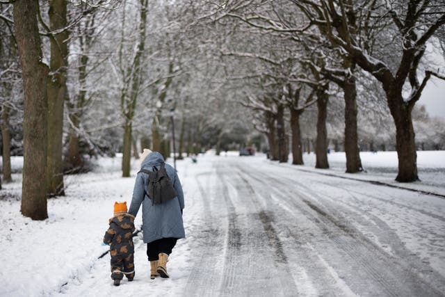 <p>A family walk through snow in Sefton Park in Liverpool</p>